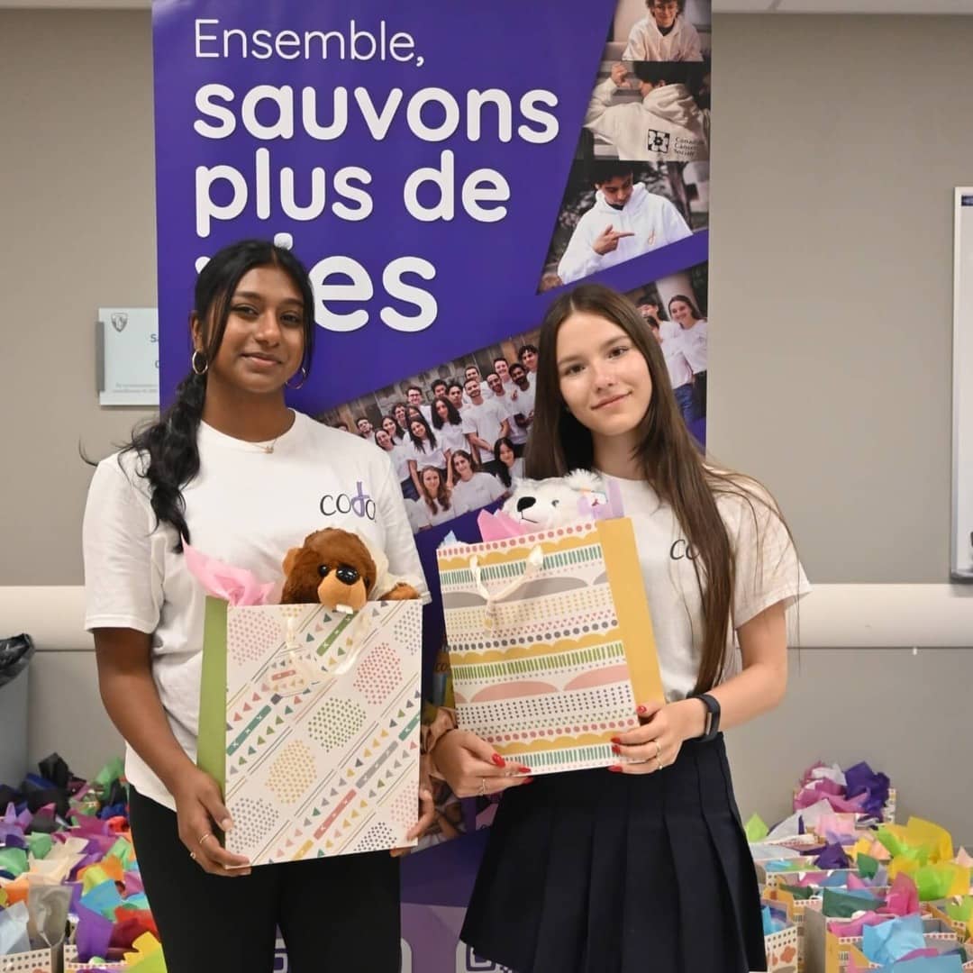 Volunteers holding gift bags during our annual Christmas in July event. 