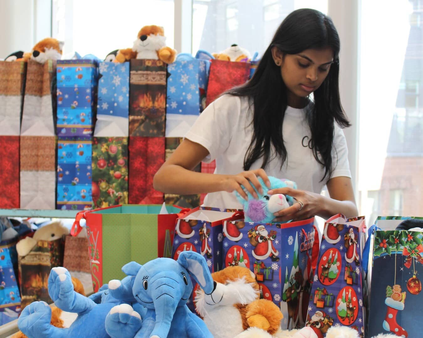 One of our members assembling gift bags at our 2024 Christmas in July event