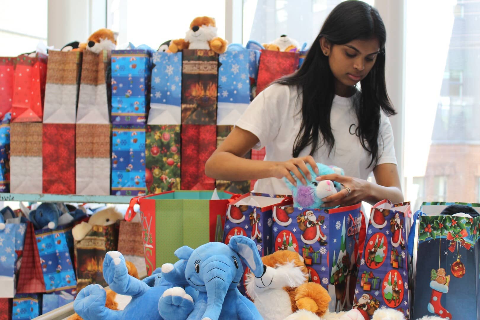 One of our members assembling gift bags at our 2024 Christmas in July event